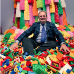 Gary Stager sitting in a pile of lego