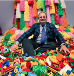 Gary Stager sitting in a pile of lego